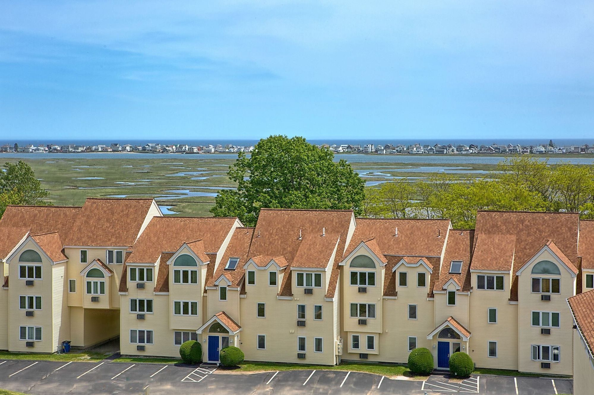Condominium buildings at Village by the Sea in Wells, Maine, with the tidal marsh, harbor and ocean in the background