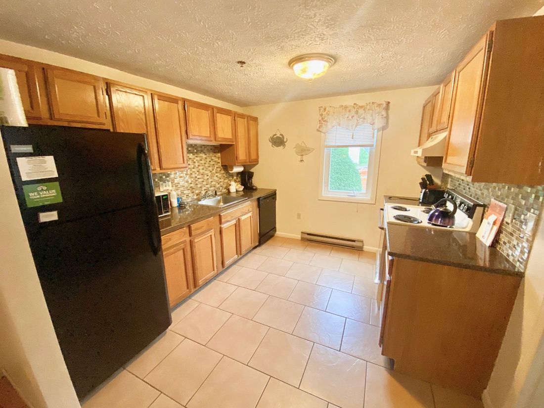 A full kitchen in a furnished condominium suite at Village by the Sea in Wells, Maine