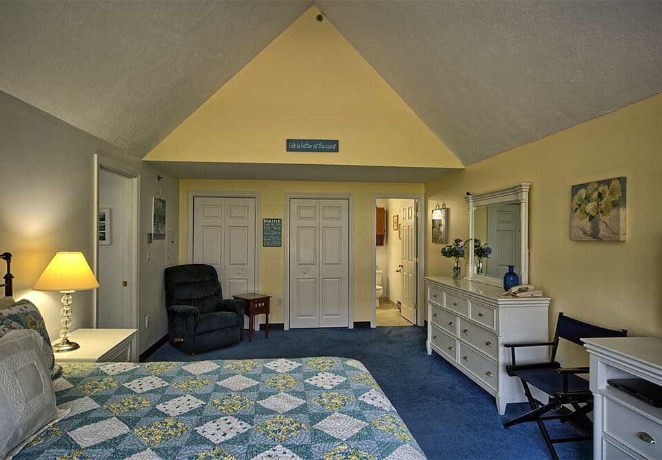 Large Bedroom with yellow walls and white furniture in our Maine vacation rental