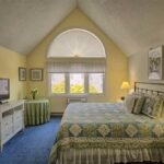 Bedroom with yellow walls and large windows in Wells Maine near the beach