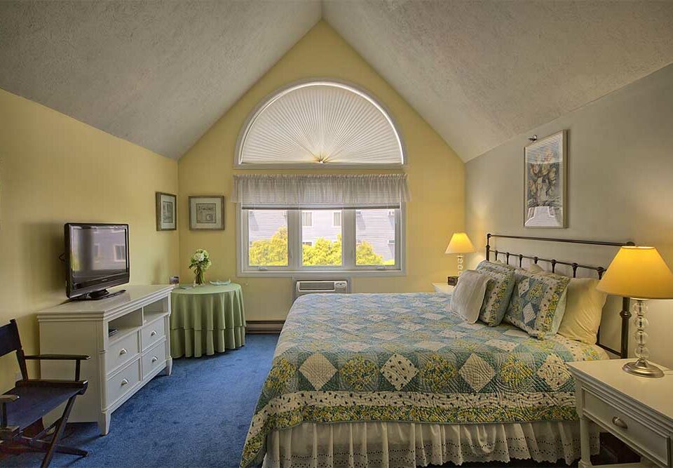 Bedroom with yellow walls and large windows in Wells Maine near the beach