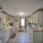 Kitchen with white cabinets in our 2 bedroom suite in Wells maine
