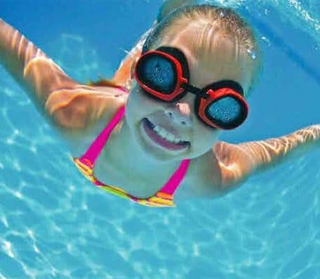Child swimming under water with goggles on